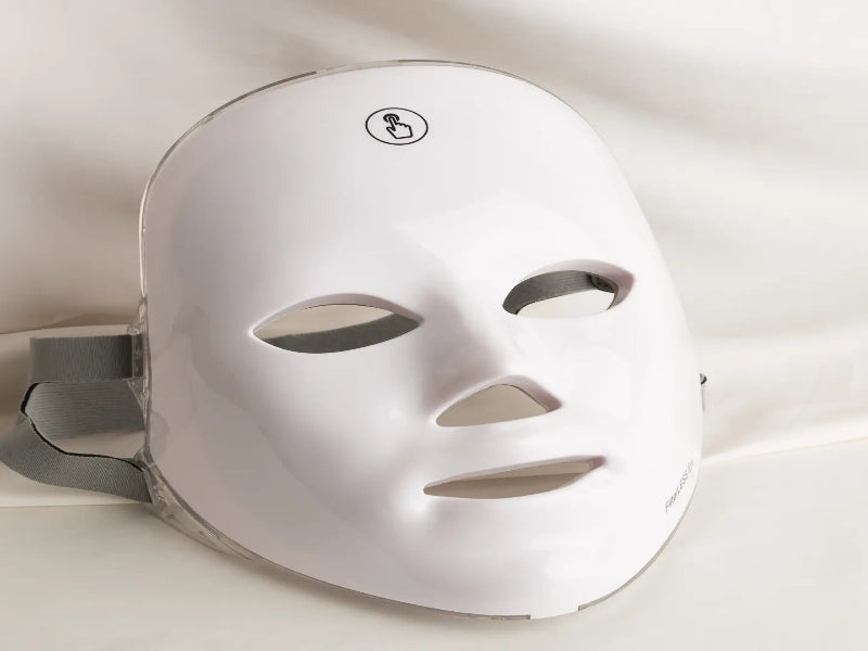 White LED face mask on a light gray background